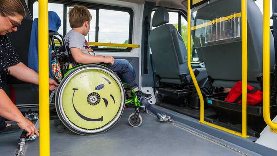 Enfant en fauteuil dans un minibus adapté